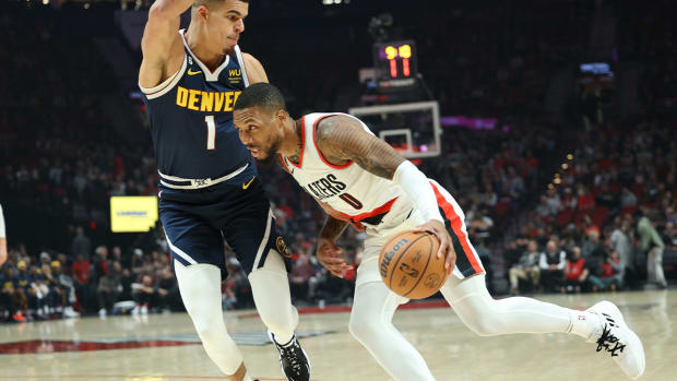 Oct 24, 2022; Portland, Oregon, USA; Portland Trail Blazers guard Damian Lillard (0) drives on Denver Nuggets forward Michael Porter Jr. (1) in the first half at Moda Center.